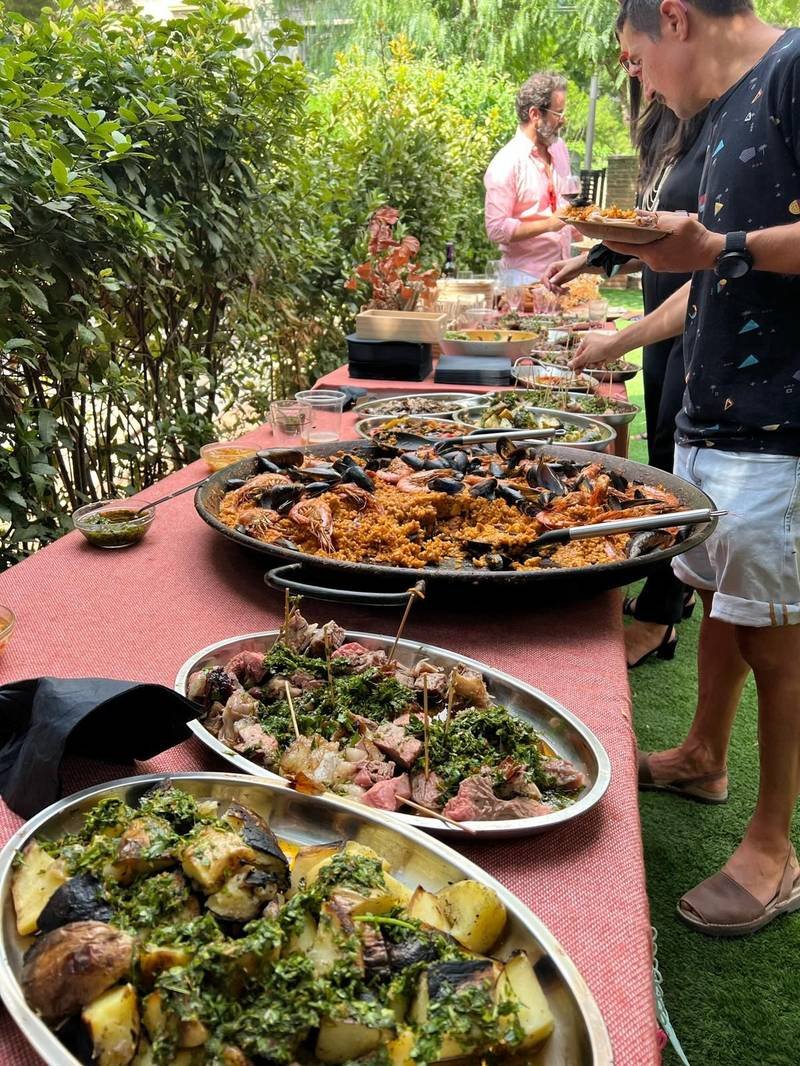 Bufé de evento corporativo con paella y pinchos de carne